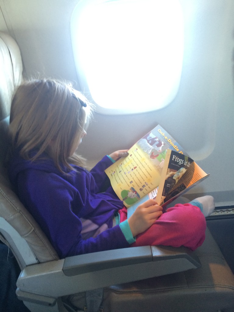 Girl on airplane with magazine